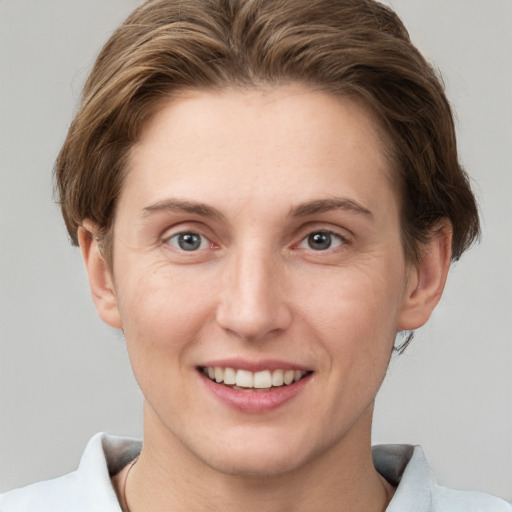 Joyful white young-adult female with short  brown hair and grey eyes