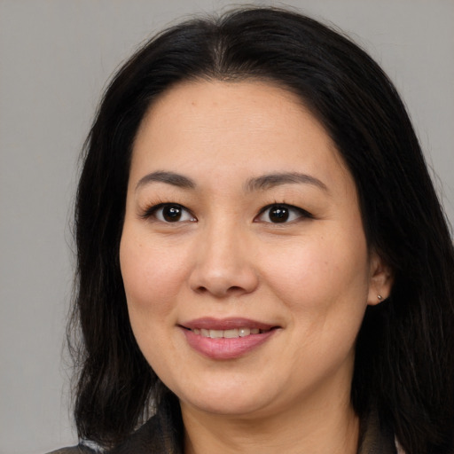 Joyful asian young-adult female with long  brown hair and brown eyes