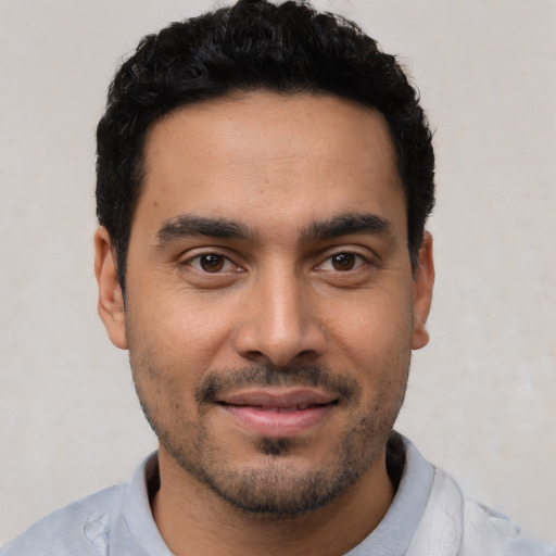 Joyful latino young-adult male with short  black hair and brown eyes