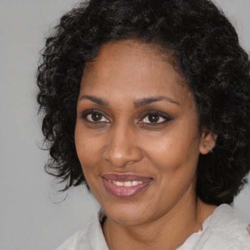 Joyful black adult female with medium  black hair and brown eyes
