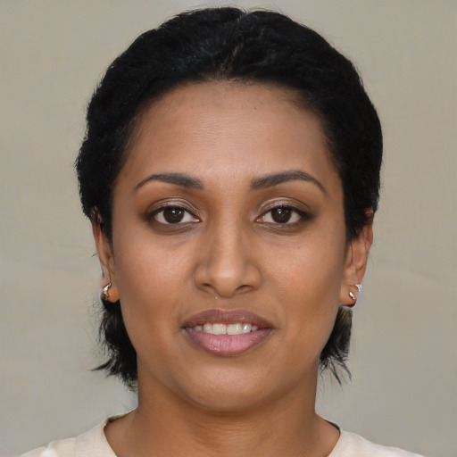 Joyful latino young-adult female with short  black hair and brown eyes