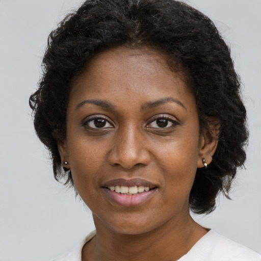 Joyful black young-adult female with short  brown hair and brown eyes