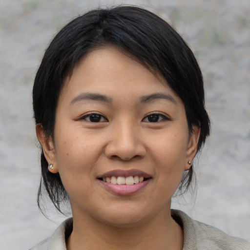 Joyful asian young-adult female with medium  black hair and brown eyes