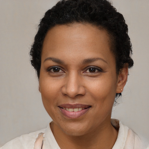 Joyful black young-adult female with short  brown hair and brown eyes