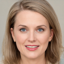 Joyful white young-adult female with medium  brown hair and blue eyes