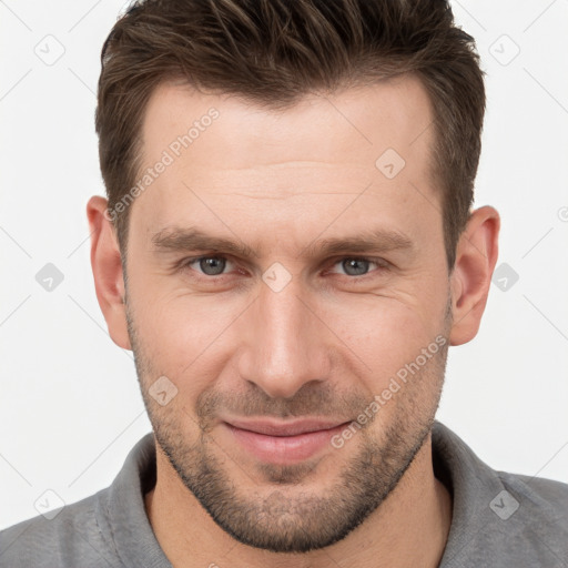 Joyful white young-adult male with short  brown hair and grey eyes