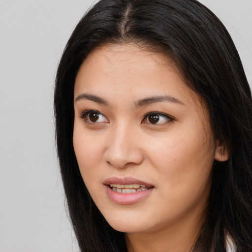 Joyful asian young-adult female with long  brown hair and brown eyes