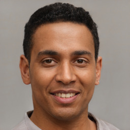 Joyful latino young-adult male with short  brown hair and brown eyes