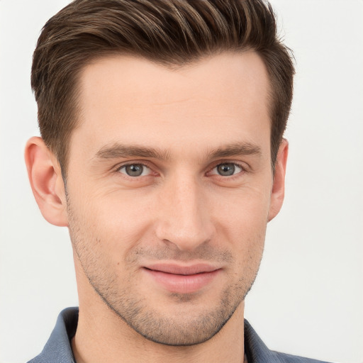 Joyful white young-adult male with short  brown hair and grey eyes