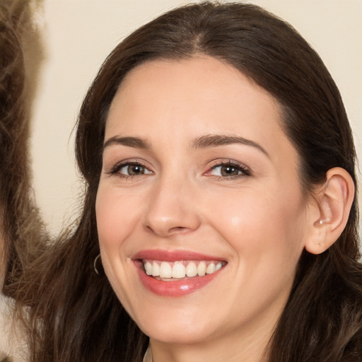 Joyful white young-adult female with long  brown hair and brown eyes