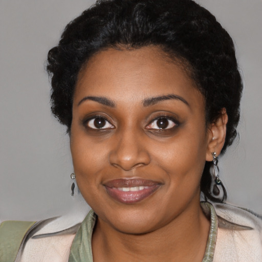 Joyful black young-adult female with short  black hair and brown eyes