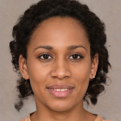 Joyful black young-adult female with medium  brown hair and brown eyes