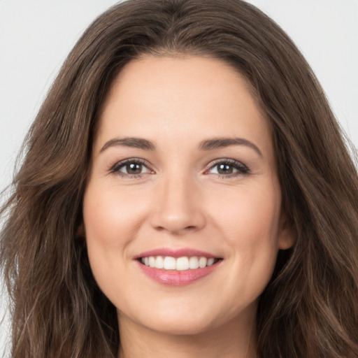 Joyful white young-adult female with long  brown hair and brown eyes