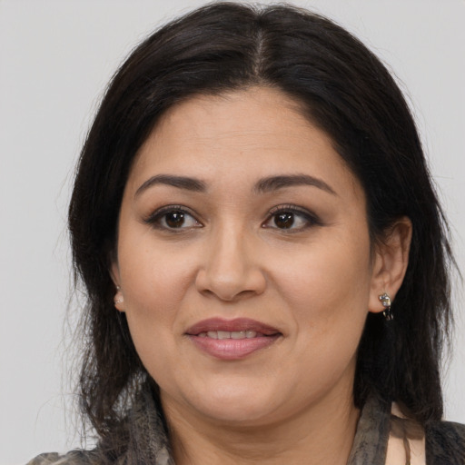 Joyful latino adult female with long  brown hair and brown eyes