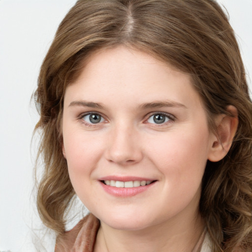 Joyful white young-adult female with long  brown hair and blue eyes