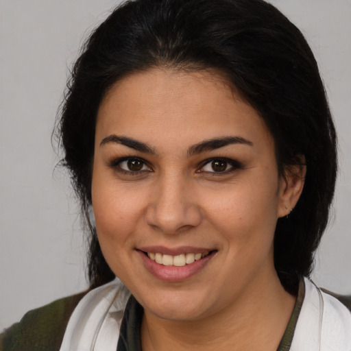 Joyful latino young-adult female with medium  brown hair and brown eyes