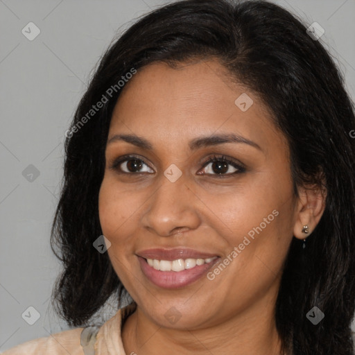 Joyful black young-adult female with long  brown hair and brown eyes