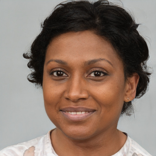 Joyful black adult female with short  brown hair and brown eyes