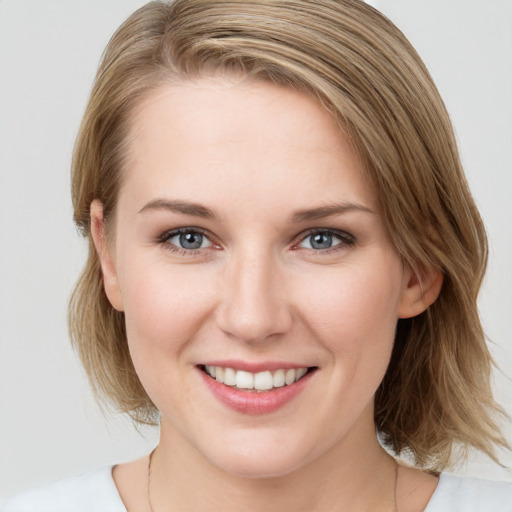 Joyful white young-adult female with medium  brown hair and blue eyes