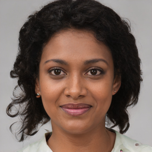 Joyful black young-adult female with medium  brown hair and brown eyes