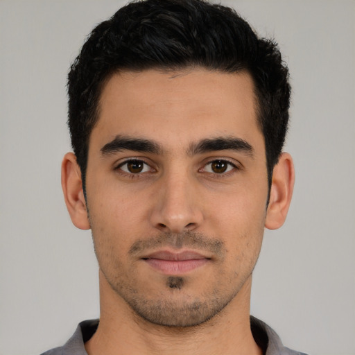 Joyful white young-adult male with short  black hair and brown eyes