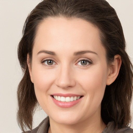 Joyful white young-adult female with long  brown hair and grey eyes