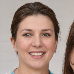 Joyful white young-adult female with medium  brown hair and grey eyes