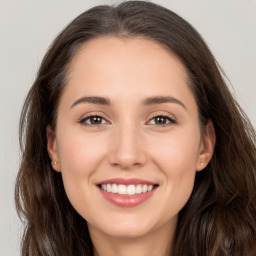 Joyful white young-adult female with long  brown hair and brown eyes