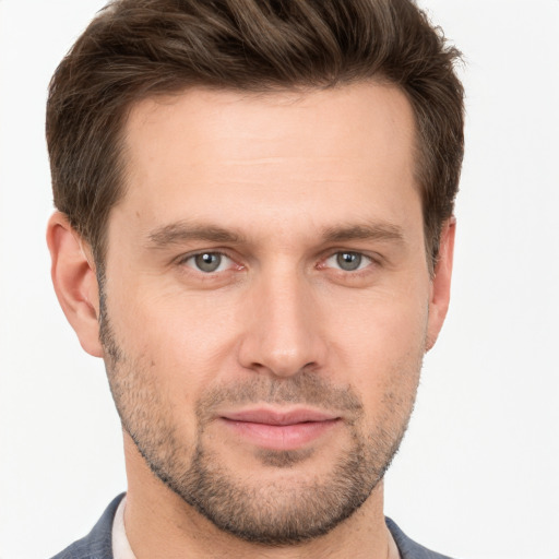 Joyful white young-adult male with short  brown hair and grey eyes