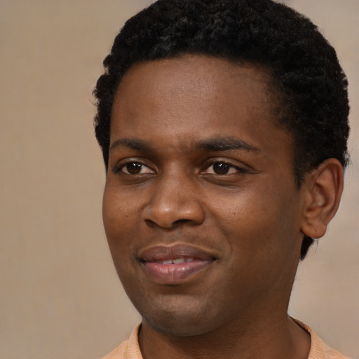 Joyful black young-adult male with short  black hair and brown eyes