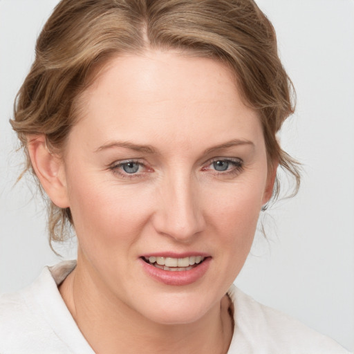 Joyful white young-adult female with medium  brown hair and blue eyes