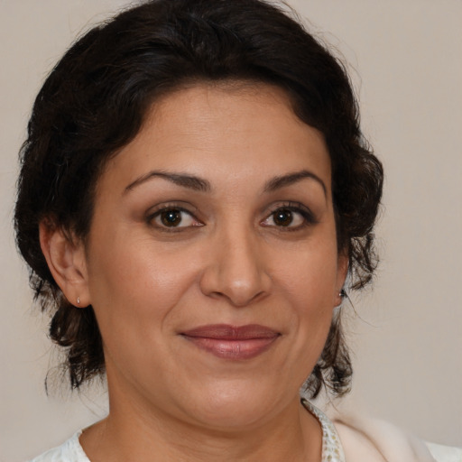 Joyful latino adult female with medium  brown hair and brown eyes