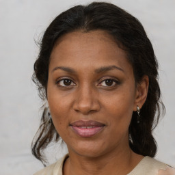 Joyful black adult female with medium  brown hair and brown eyes