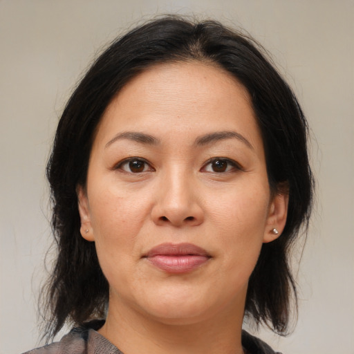 Joyful asian adult female with medium  brown hair and brown eyes