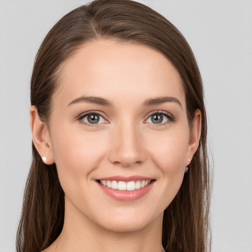 Joyful white young-adult female with long  brown hair and grey eyes