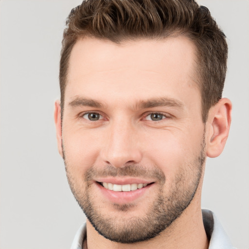 Joyful white young-adult male with short  brown hair and grey eyes