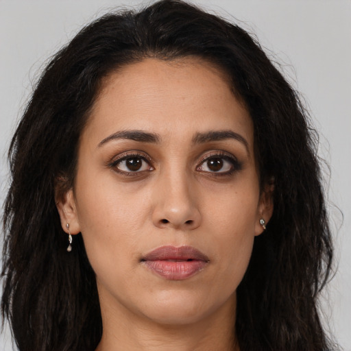 Joyful latino young-adult female with long  brown hair and brown eyes