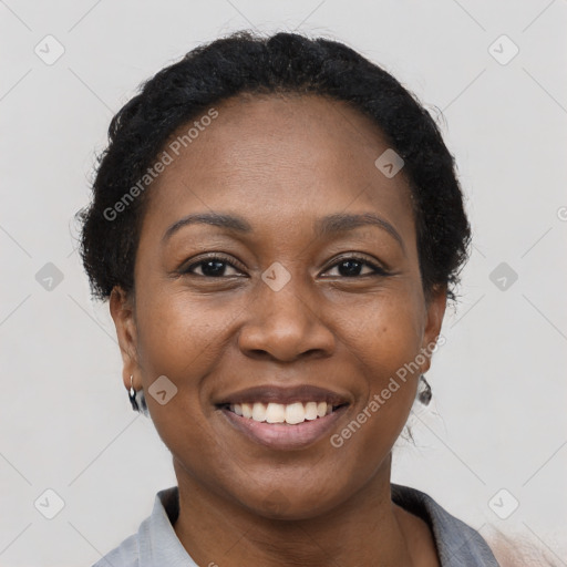 Joyful black adult female with short  black hair and brown eyes