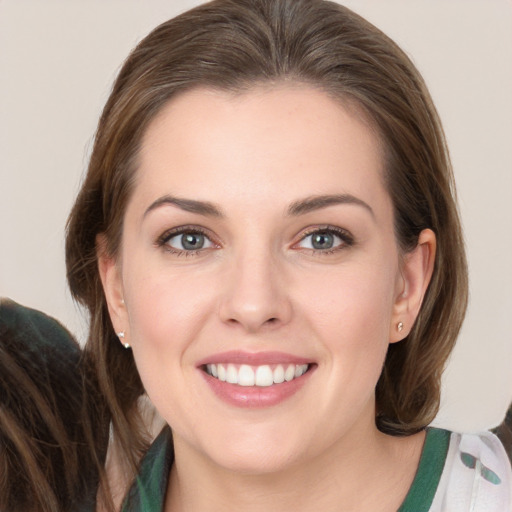 Joyful white young-adult female with medium  brown hair and grey eyes