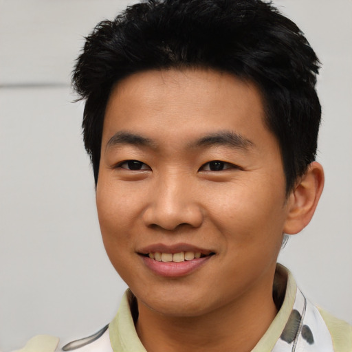 Joyful asian young-adult male with short  black hair and brown eyes