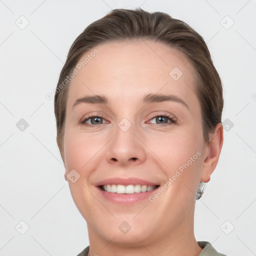 Joyful white young-adult female with short  brown hair and grey eyes