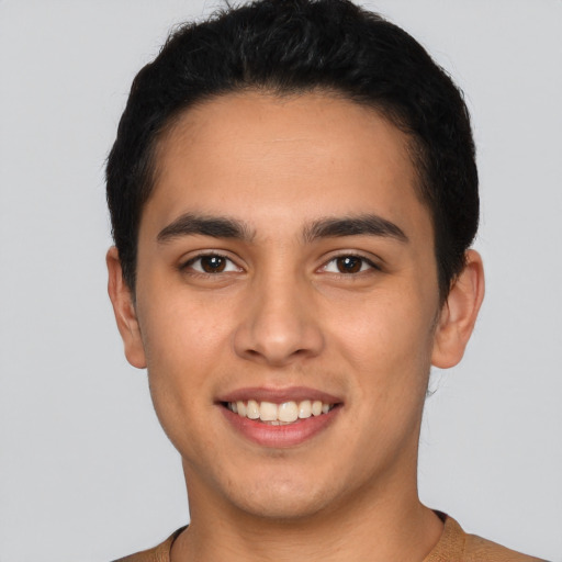 Joyful latino young-adult male with short  brown hair and brown eyes