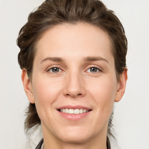 Joyful white adult female with medium  brown hair and grey eyes