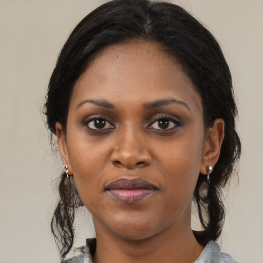 Joyful black young-adult female with medium  black hair and brown eyes