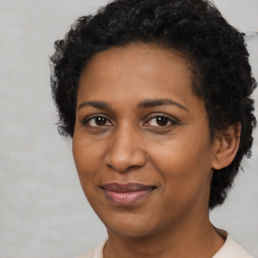 Joyful black adult female with short  black hair and brown eyes