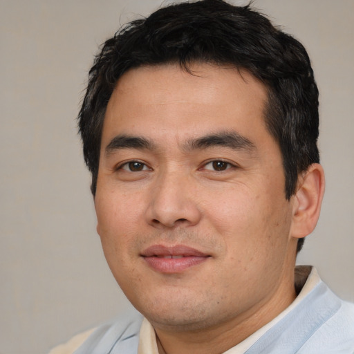 Joyful asian young-adult male with short  brown hair and brown eyes