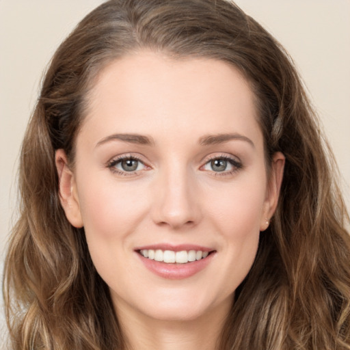 Joyful white young-adult female with long  brown hair and green eyes