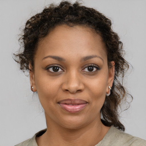 Joyful black young-adult female with medium  brown hair and brown eyes