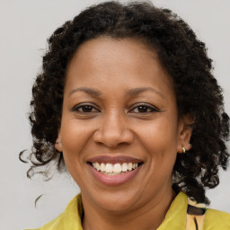 Joyful black adult female with medium  brown hair and brown eyes