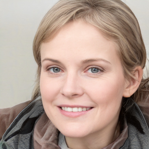 Joyful white young-adult female with medium  brown hair and blue eyes